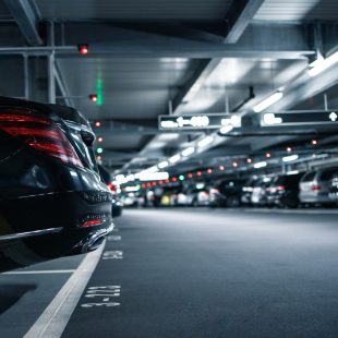 A closeup of a black car in a parking garage