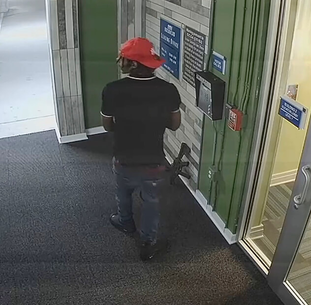 A man trying to break into a building with a gun
